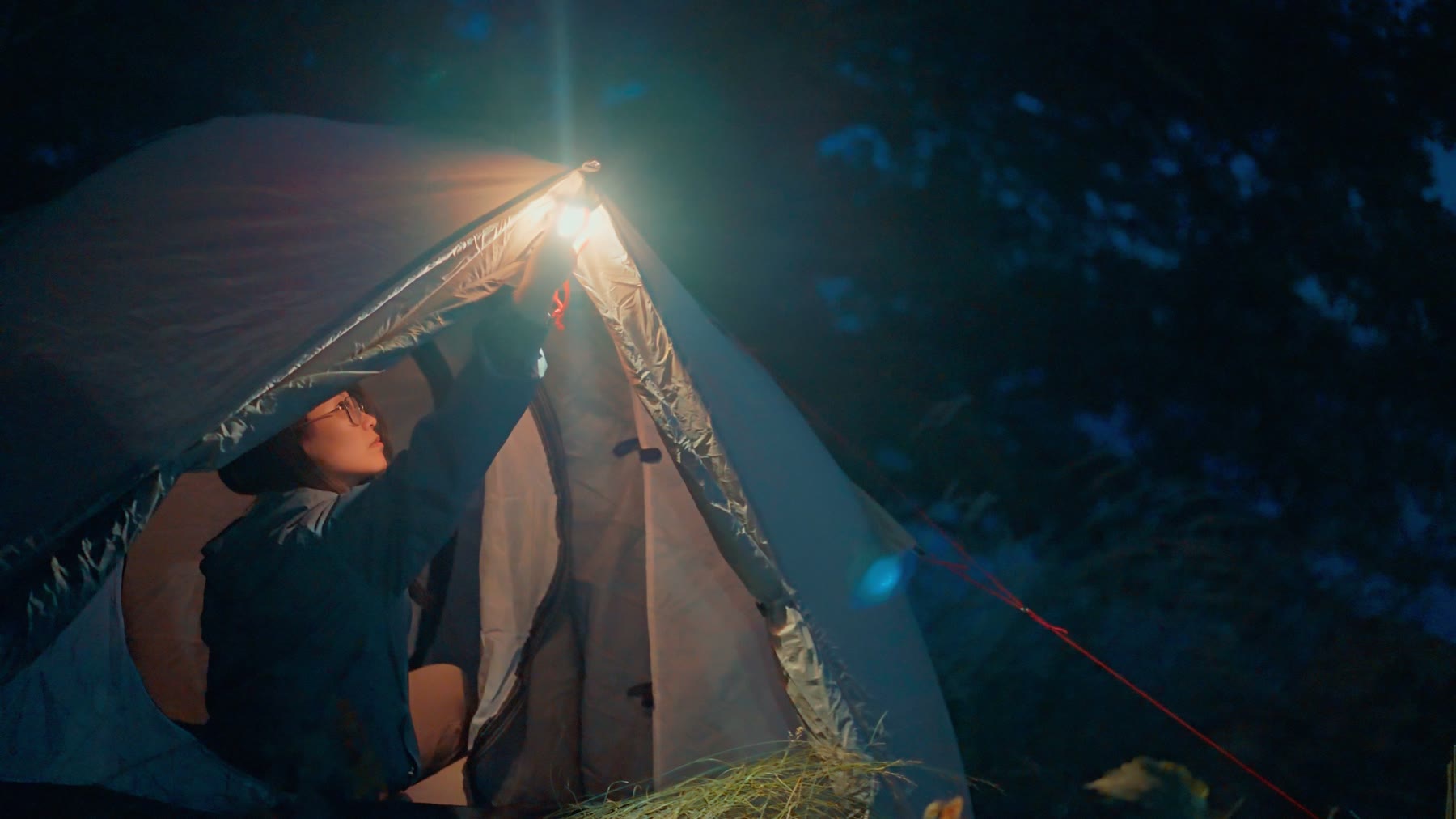 Illuminated tent glowing at a campsite at night